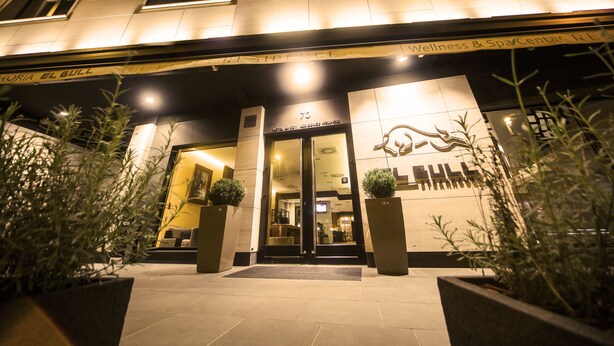 Entrada de hotel com uma placa indicando "Wellness & Spa/Cental RESIDENCE 70".
