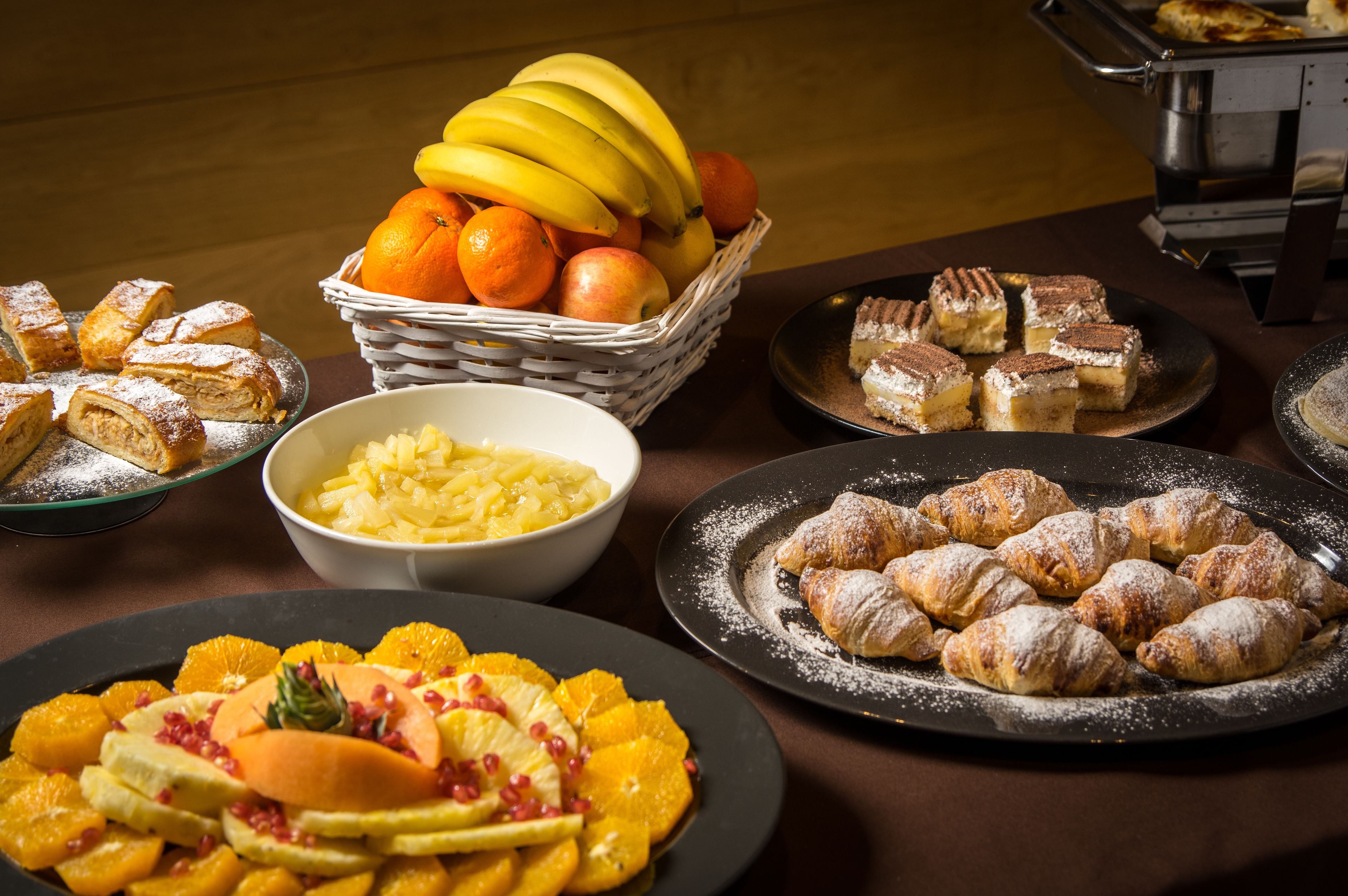 Een buffet met diverse desserts en fruit.