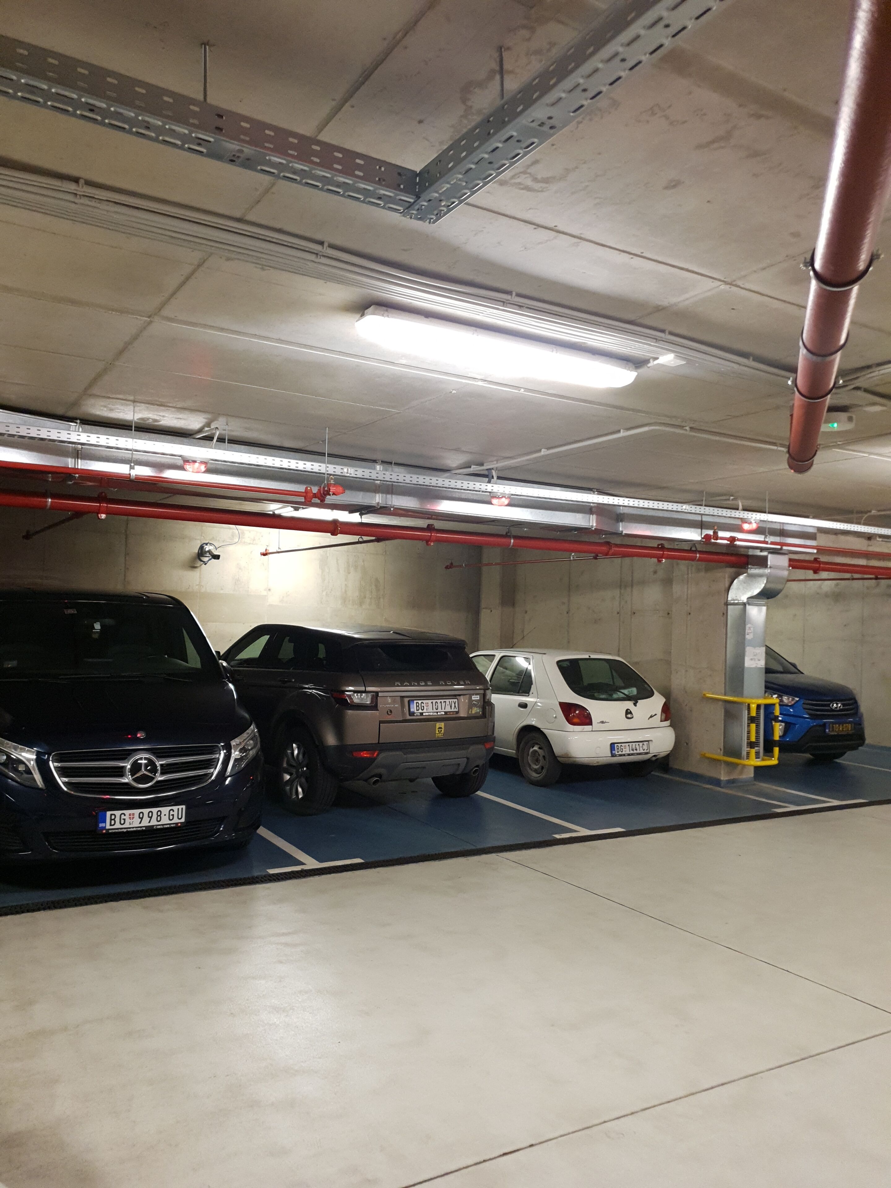 A parking garage with multiple cars parked in designated spaces.