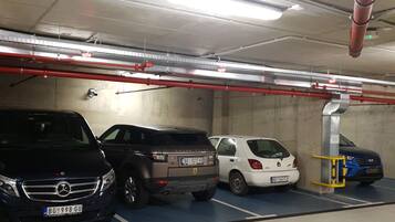 A parking garage with multiple cars parked in designated spaces.