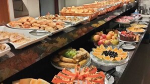 A buffet with various food items and utensils. - Bravo City Hotel Dourados (Dourados)
