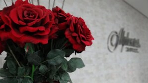 A bouquet of red roses in a red vase. - Bravo City Hotel Dourados (Dourados)