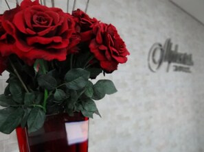 A bouquet of red roses in a red vase. - Bravo City Hotel Dourados (Dourados)