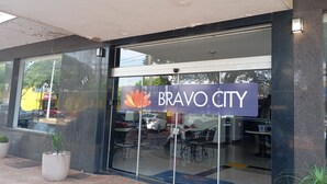 A restaurant with a glass facade, outdoor seating, and a sign reading 'Bravo City'. - Bravo City Hotel Dourados (Dourados)