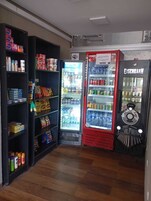A vending area with snack and drink options, including a Coca-Cola refrigerator and a Eisenschmuck vending machine.