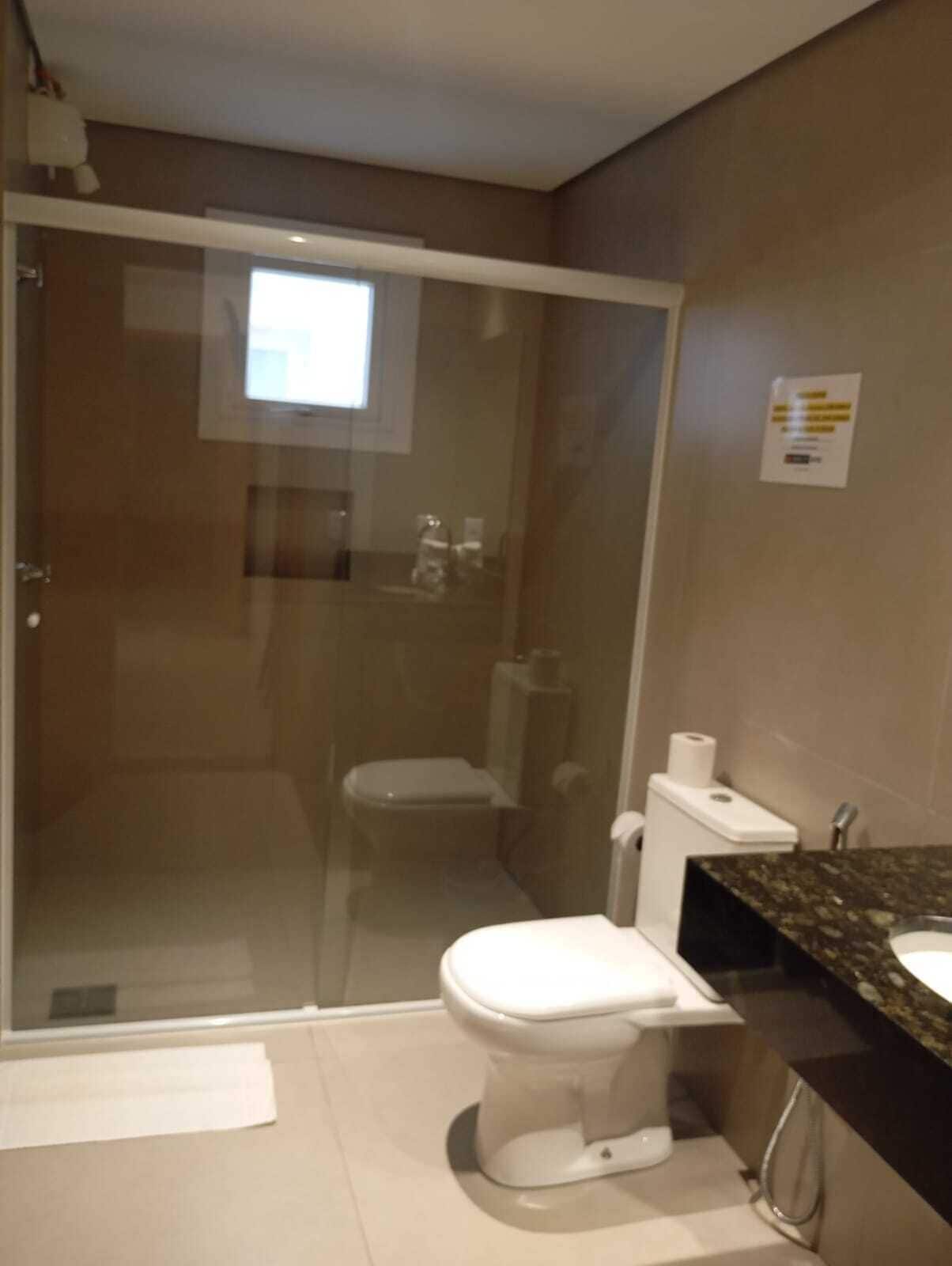 Un baño con inodoro, cabina de ducha y lavabo.