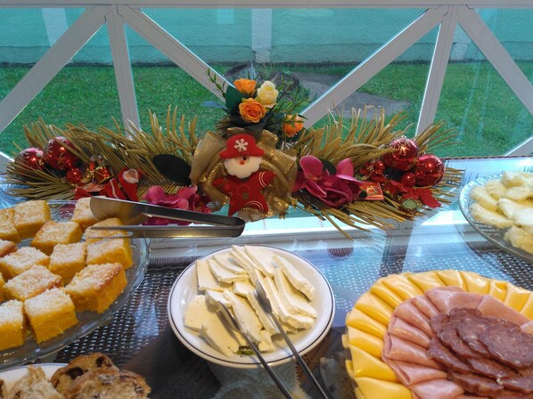 A buffet table with various food items and a Christmas decoration.
