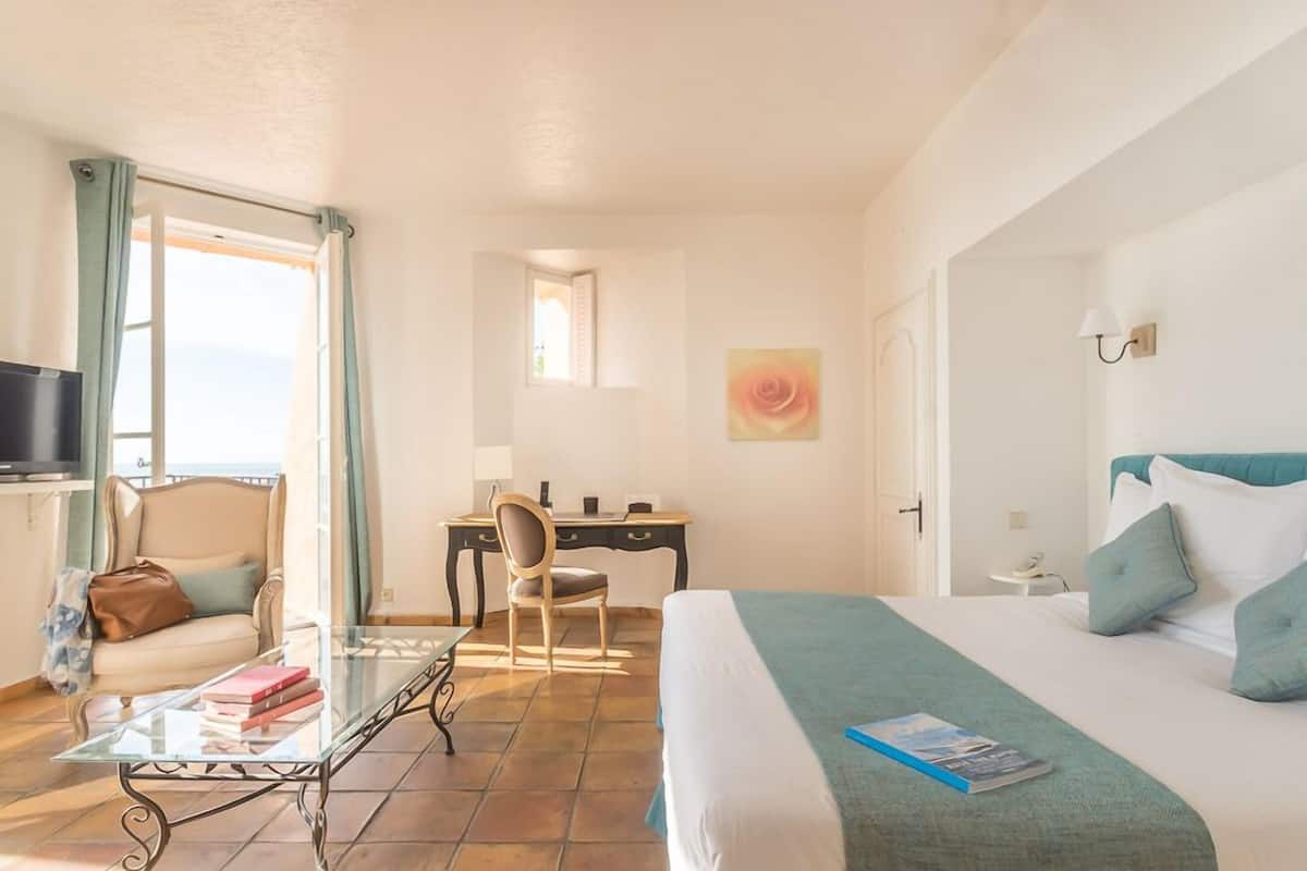 Ein Hotelzimmer mit Bett, Schreibtisch, Stuhl, Fernseher und Fenster.