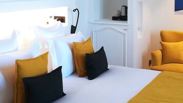 A hotel room with a bed, a sofa, and a nightstand.
