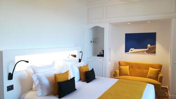 Ein Hotelzimmer mit einem großen Bett, einer Couch, einem Gemälde und einer Deckenleuchte.