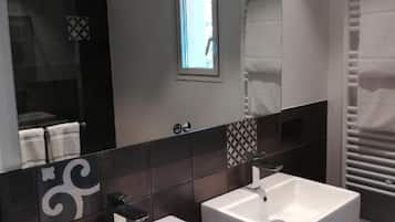 A modern bathroom with two white sinks, a large mirror, and a towel rack.
