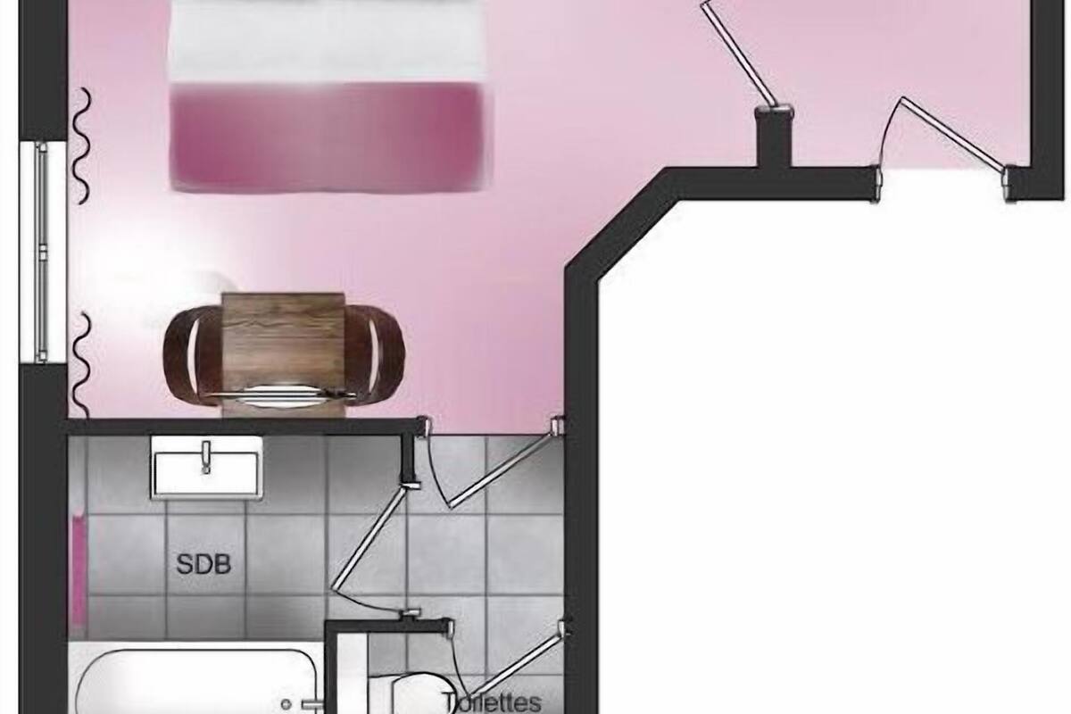 A bedroom with a bed, a window, and a bathroom with a toilet and sink.