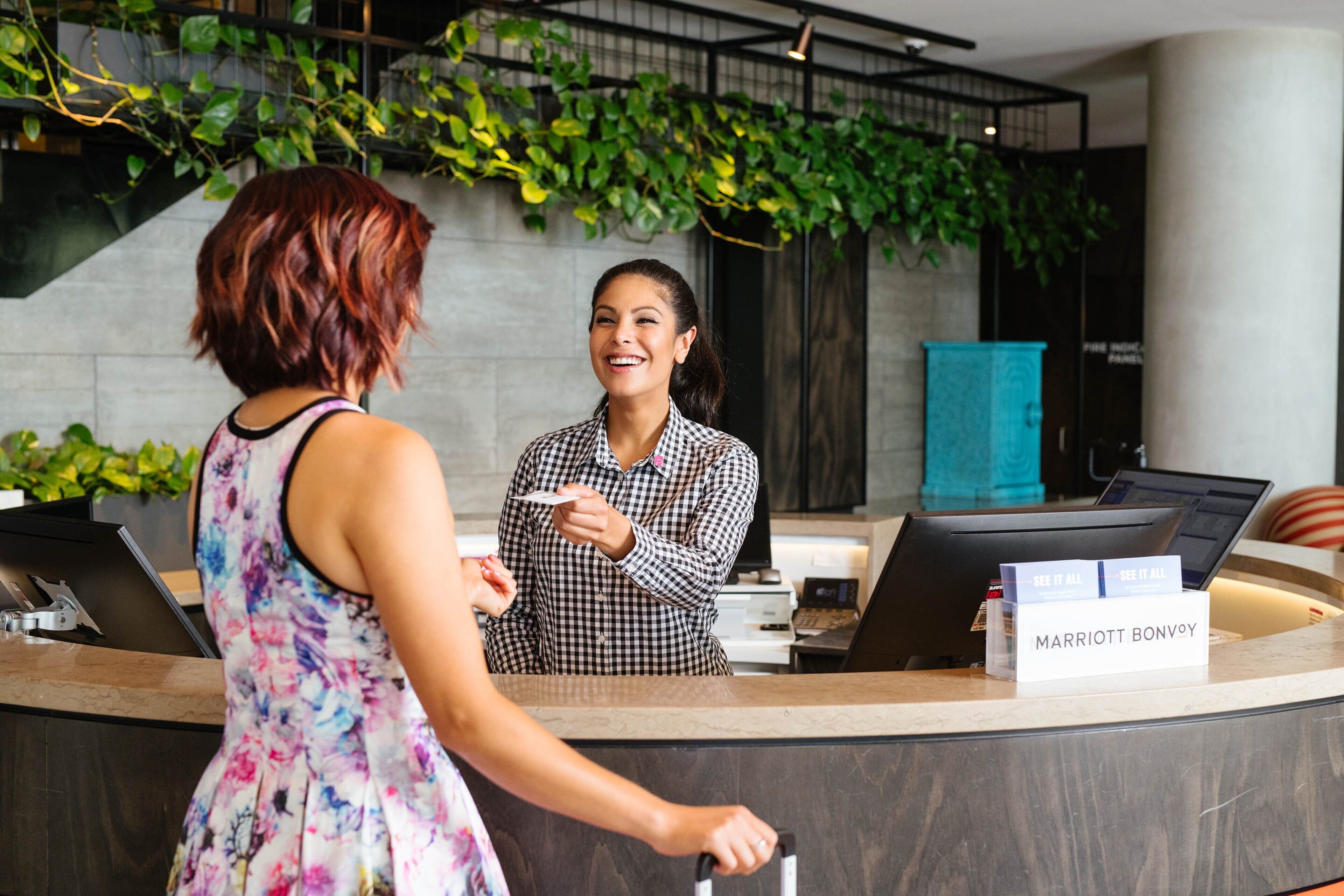 A reception desk with a sign reading "MARRIOTT BONVOY" and a check-in counter.