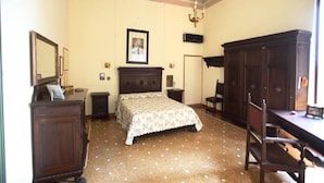 Une chambre à coucher comprenant un lit, une commode, une chaise et un bureau avec une autre chaise.