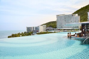 A hotel with a large infinity pool overlooking the sea, modern architecture, and a view of the ocean. - The Shanhaitian Resort Sanya, Autograph Collection (Sanya)