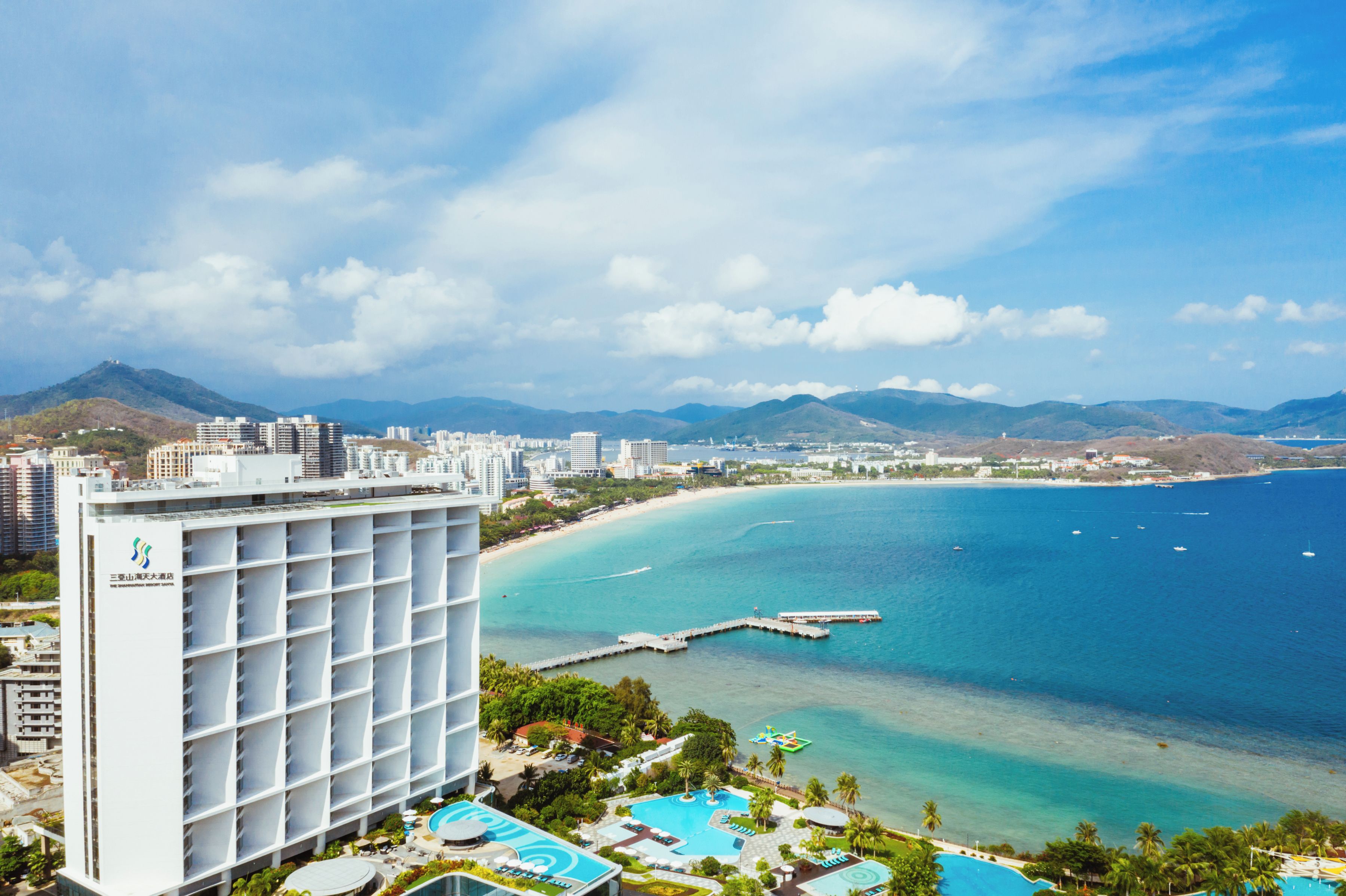 A hotel with a pool area and a view of the ocean.