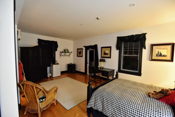 A bedroom with a bed, a chair, a desk, and a wardrobe. - The Burleigh Falls Inn & Suites (North Kawartha)