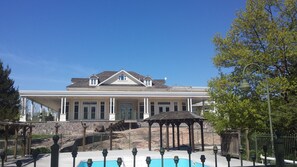 A large, two-story building with a covered patio area and a swimming pool in front. - The Burleigh Falls Inn & Suites (North Kawartha)