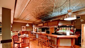 Eine Bar mit Holzkubaturen, einer Theke und einer dekorativen Decke.