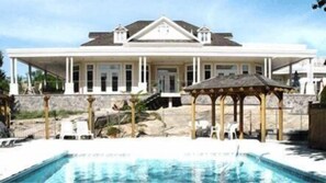 A large house with a swimming pool, a gazebo, and a patio area with chairs. - The Burleigh Falls Inn & Suites (North Kawartha)