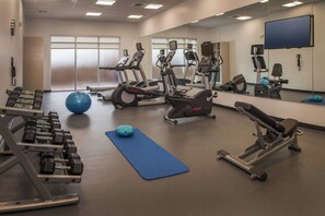 A gym with exercise equipment, a blue mat, and a large mirror. - Fairfield Inn and Suites by Marriott Washington (Washington)