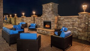 An outdoor patio area with wicker furniture and a stone fireplace. - Fairfield Inn and Suites by Marriott Washington (Washington)
