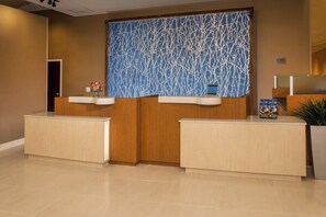 A reception area with two counters, a decorative wall, and a sign indicating no pets allowed. - Fairfield Inn and Suites by Marriott Washington (Washington)