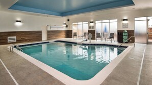 An indoor swimming pool with clear water, a blue ceiling, and a seating area with chairs and a counter. - Fairfield Inn and Suites by Marriott Washington (Washington)
