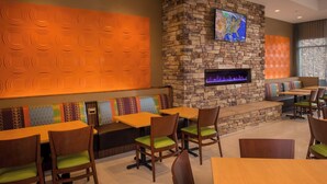A restaurant with stone walls, a fireplace, and booths with colorful cushions. - Fairfield Inn and Suites by Marriott Washington (Washington)