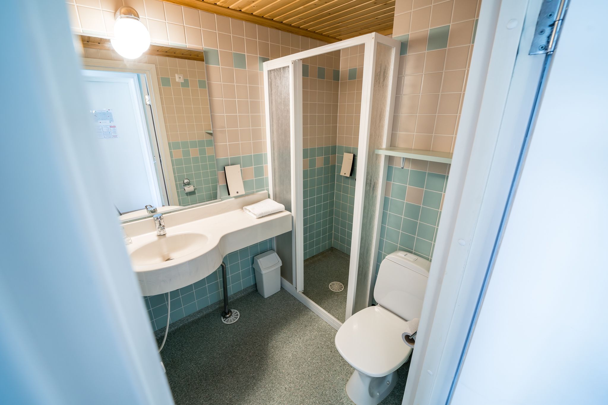 Un baño con lavamanos, inodoro y cabina de ducha.