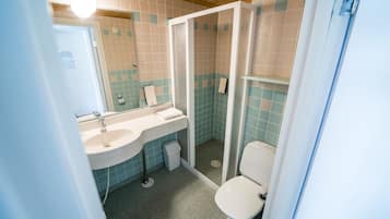 Un baño con lavamanos, inodoro y cabina de ducha.