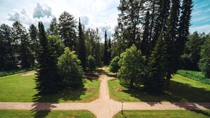 Een park met een centrale wandelpad, omgeven door bomen en gazons.