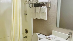 A bathroom with a shower, toilet, sink, and towel rack. - Super 8 by Wyndham Benton Harbor - St. Joseph (Benton Harbor)