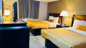 A hotel room with two beds, a desk with a computer, a lamp, and a window with curtains. - Super 8 by Wyndham Benton Harbor - St. Joseph (Benton Harbor)