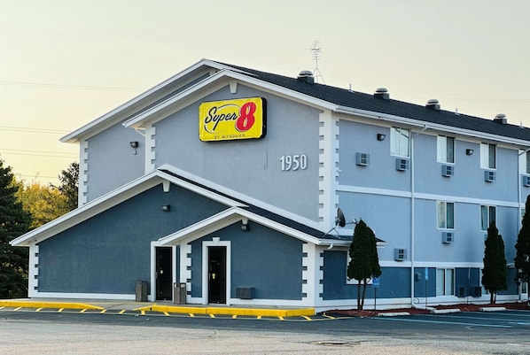 A hotel with a 'Super 8' sign, a number '1950' on the facade, and a gated entrance.