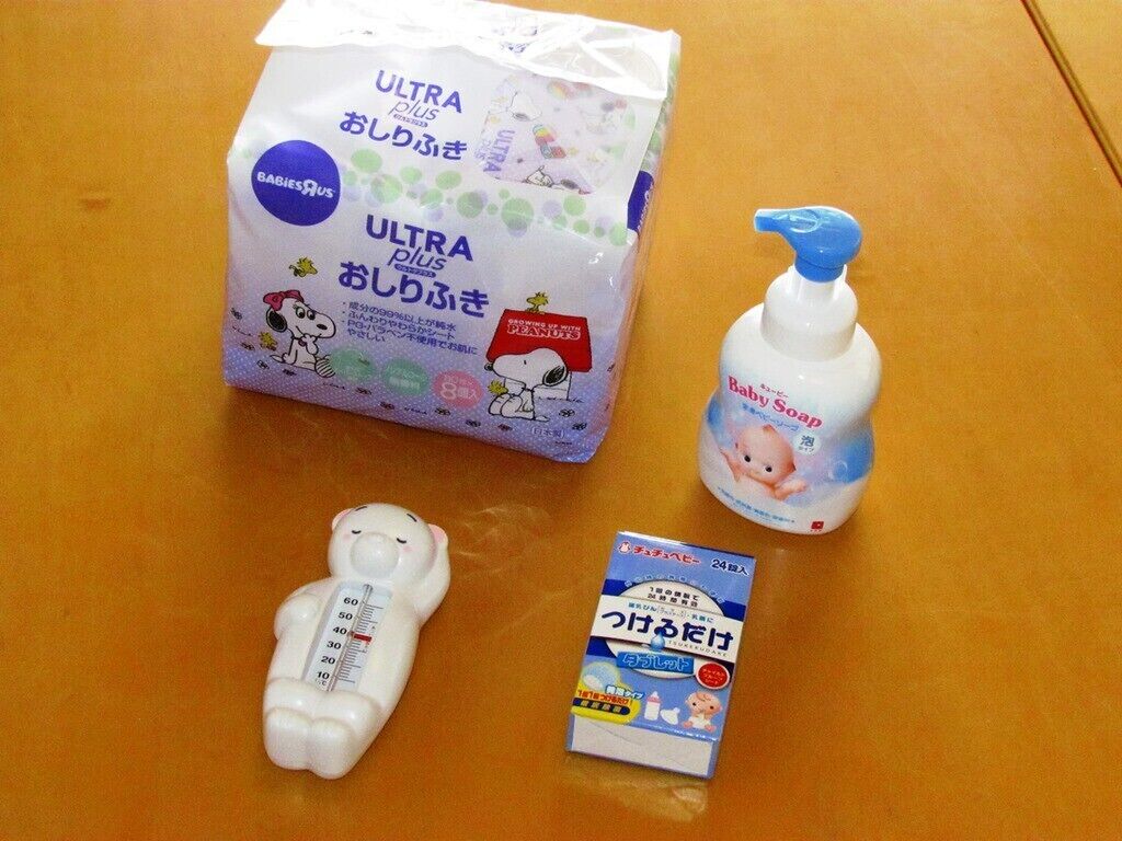 A package of Ultra diapers, a baby bottle, a baby thermometer, and a baby bottle of baby soap.