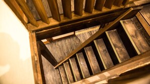 Una escalera de madera con barandilla y peldaños de madera.