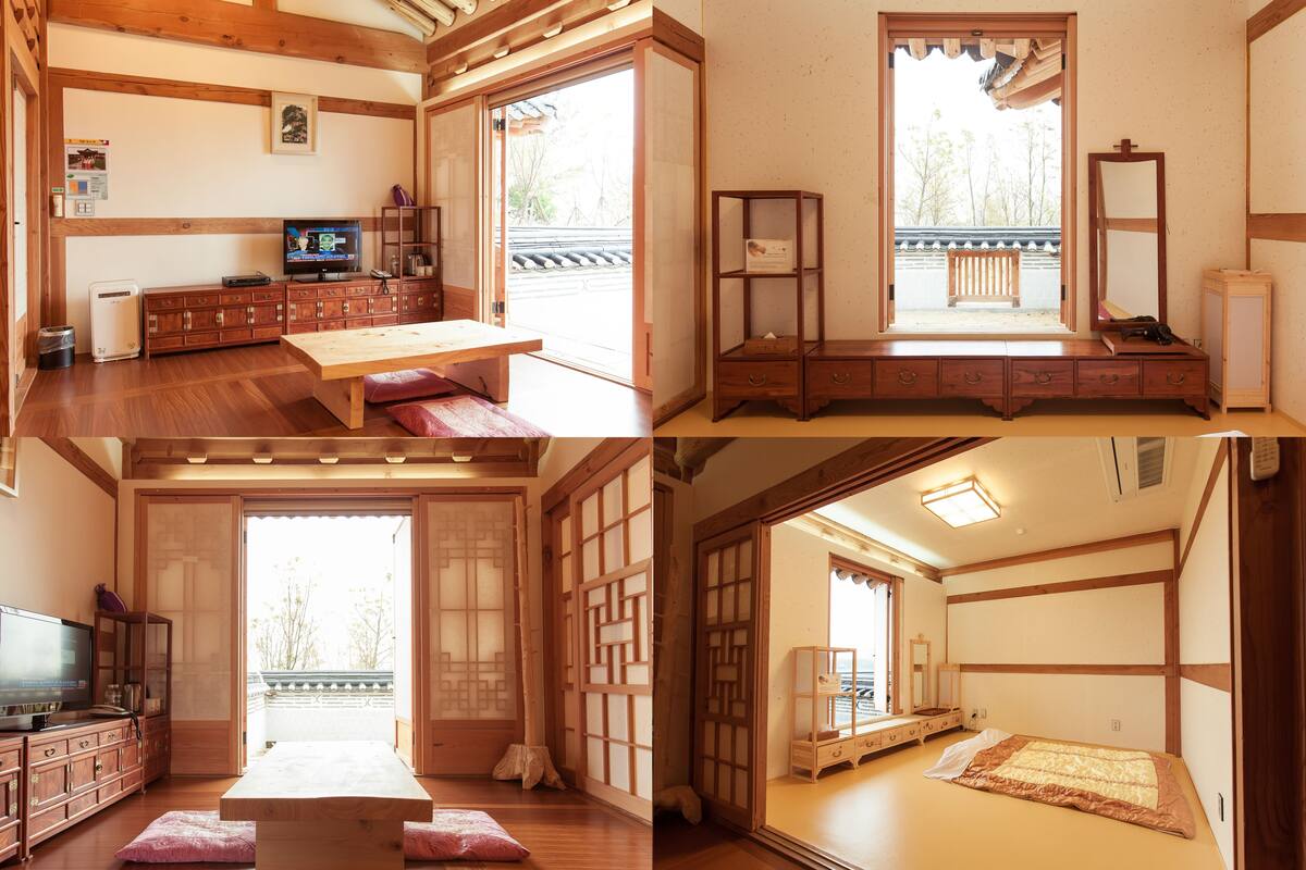 A traditional Japanese room with tatami flooring, a low wooden table, a television, and sliding doors leading to a balcony.