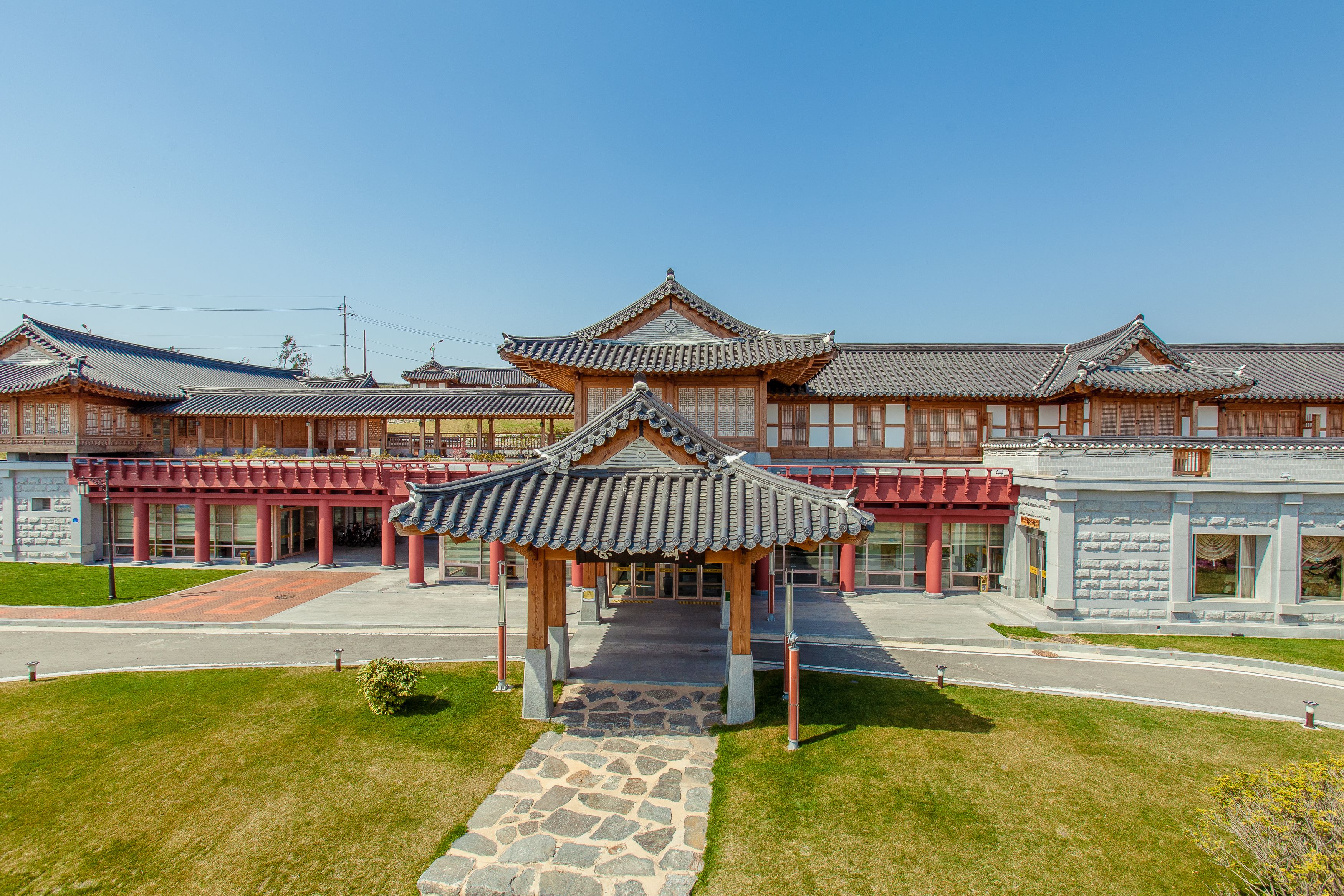 A traditional Korean building with a central pavilion and multiple buildings with tiled roofs.