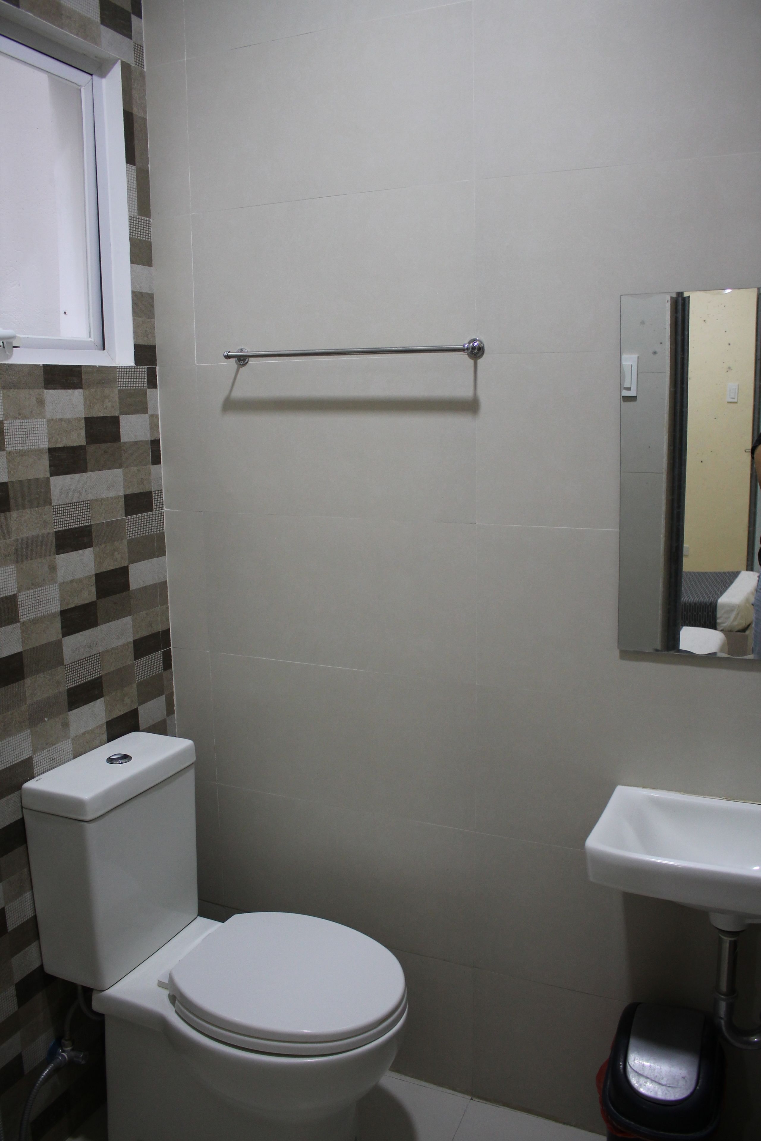 Une salle de bain avec des toilettes, un lavabo et un miroir.