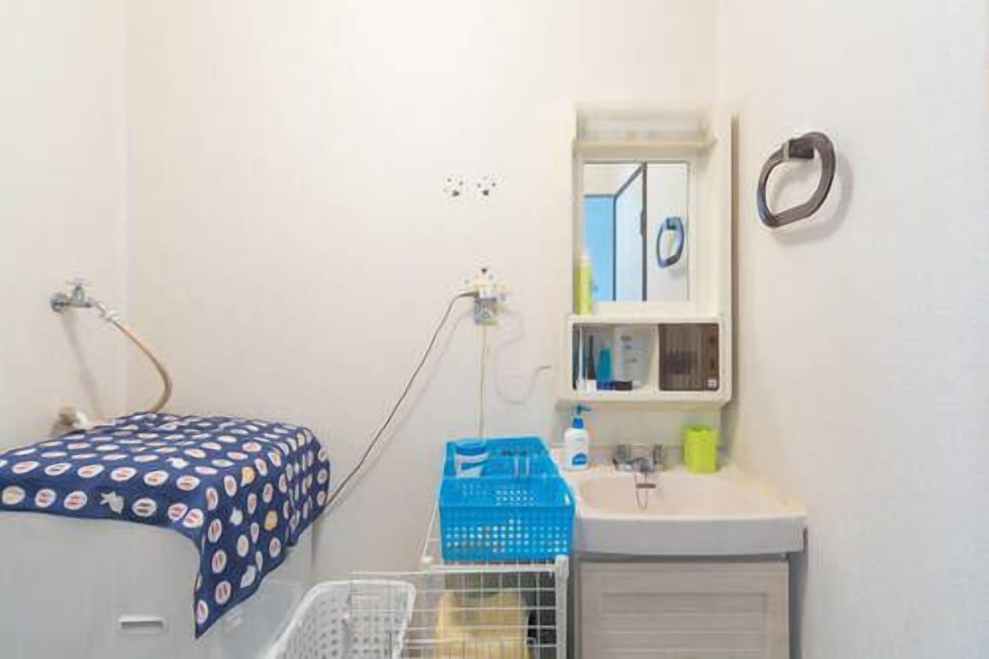 A small bathroom with a shower, a sink, and a mirror. There is a towel rack and a window with a view of the outside.