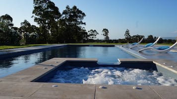 Una piscina al aire libre de temporada, sombrillas