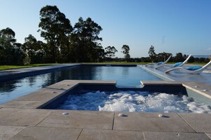Una piscina al aire libre de temporada, sombrillas