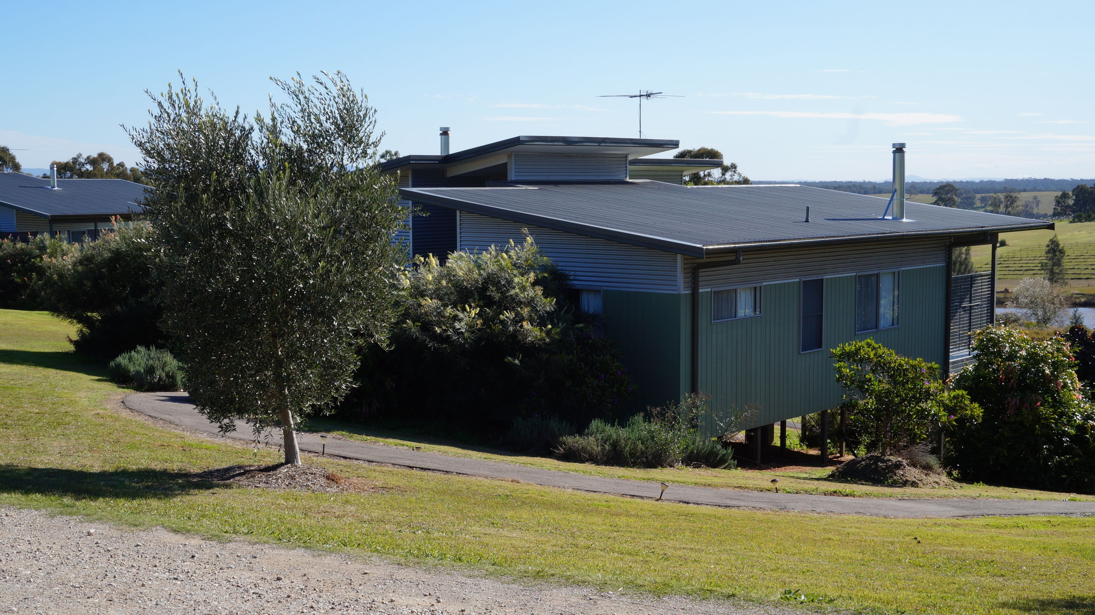 Une maison de plain-pied avec un toit en pente, une cheminée et une antenne parabolique.