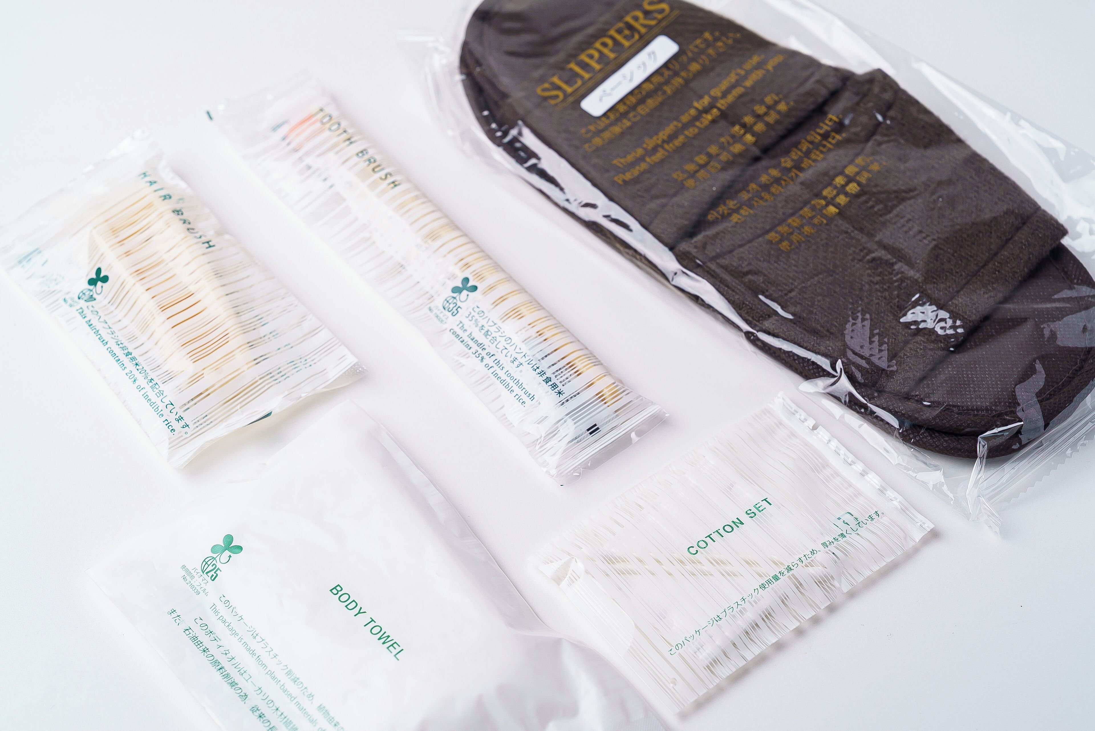 A package of slippers, a hair brush, and a cotton set.