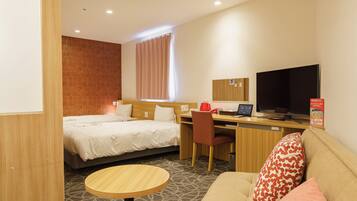 A hotel room with a bed, a desk, a television, a sofa, and a small table.