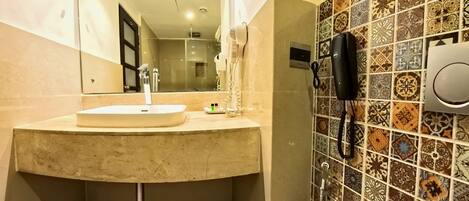 A bathroom with a sink, mirror, and shower.