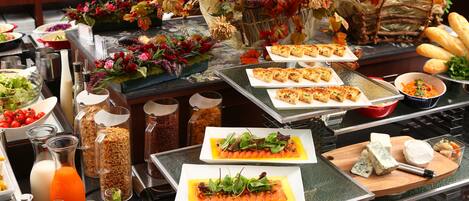 A buffet with various dishes, including salmon, cheese, and bread.