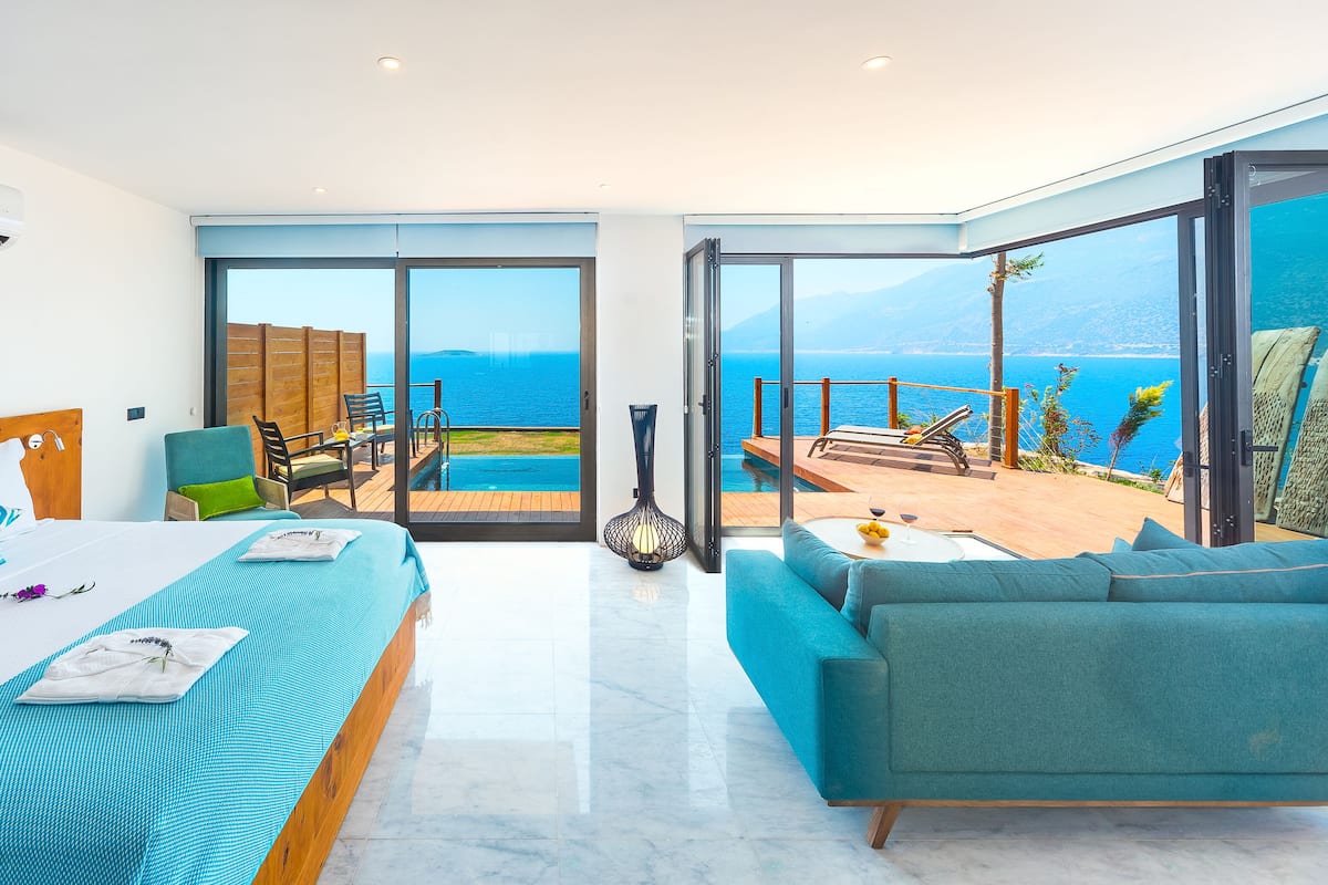 Un dormitorio moderno con una cama grande, un sofá y vistas al mar.