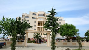 Un hotel con entrada central, varios pisos y fachada simétrica.